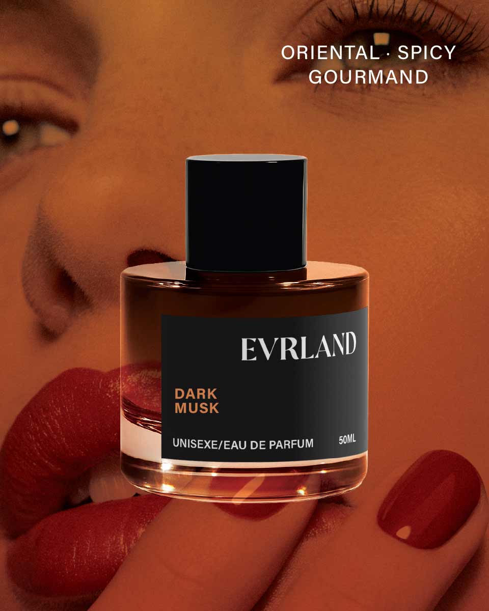 Evrland Dark Musk perfume bottle held by a hand with red nail polish, against a blurred background.